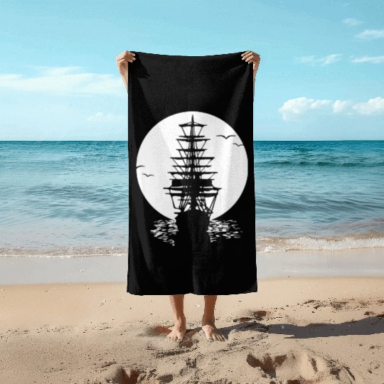 Pirate ship sails in sunset Beach Towels