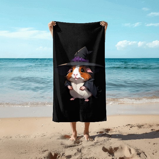 Cute Halloween guinea pig with a witch hat. Beach Towels