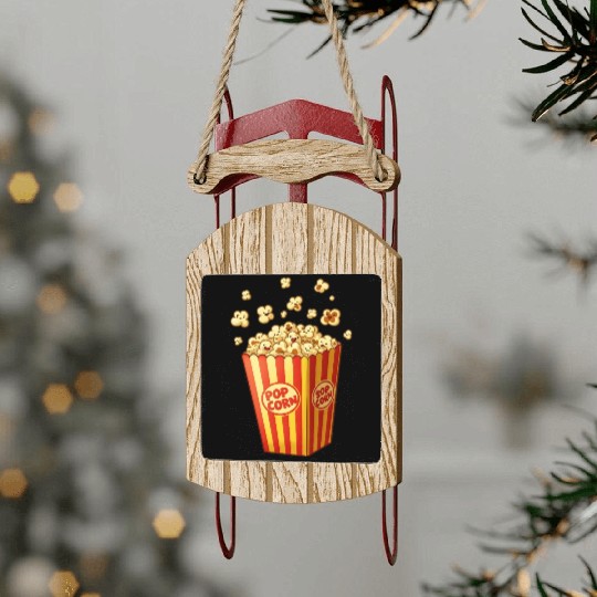 A popcorn box with little popcorn jumping out Sled Ornaments