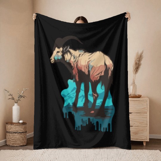 a mountain goat lives in the mountains Throw Blankets