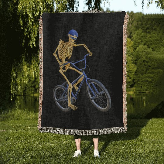 The Grim Reaper doing freestyle biking Woven Blankets